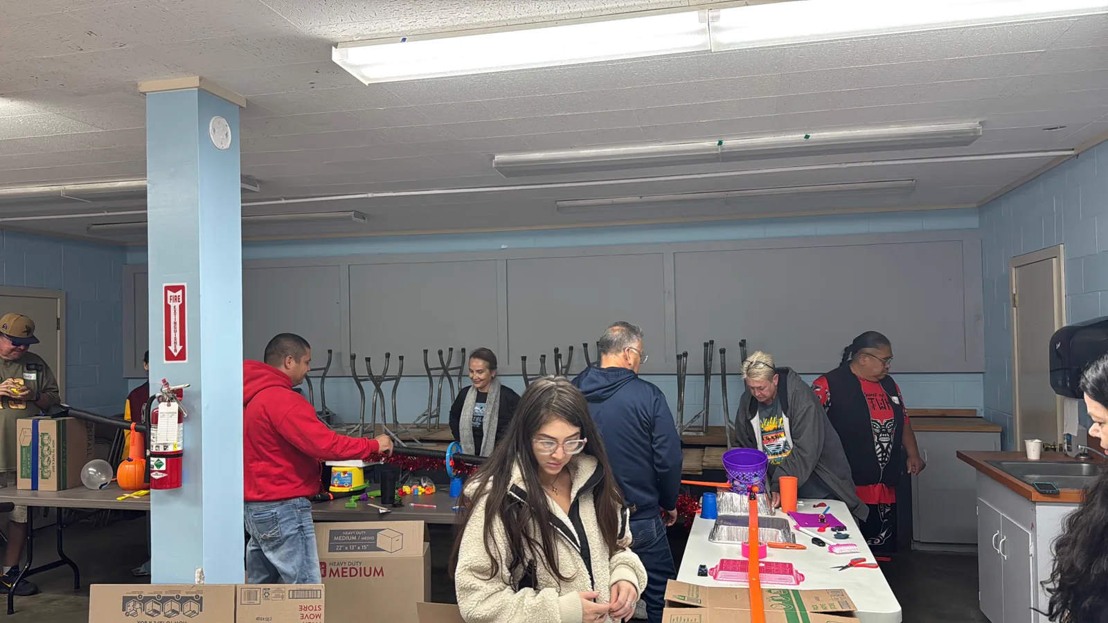 Colleagues working together around tables filled with colorful building materials.